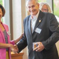 Provost Mili shakes hand with retiree.